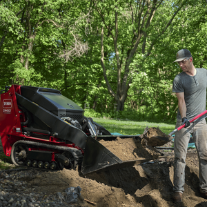 Dingo TX 550 holding dirt while man shovels