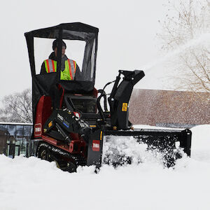 Close up of the snow thrower attachment clearing snow.