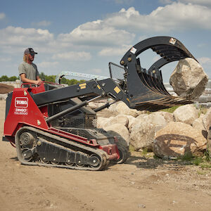 TXL 2000 carrying a big rock using the grapple attachment