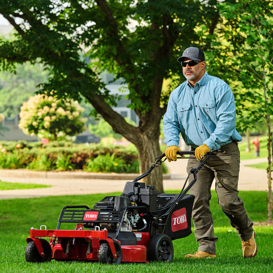 TurfMaster in Use - man mowing by trees