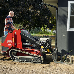 TX700 leveler attachment leveling dirt near a house