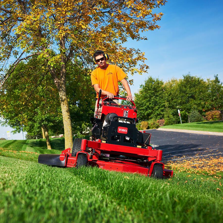 Man using a Toro GrandStand mowing the side of a hill - slight incline