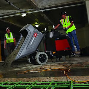 Crew dumping concrete for parking using the electric ultra buggy