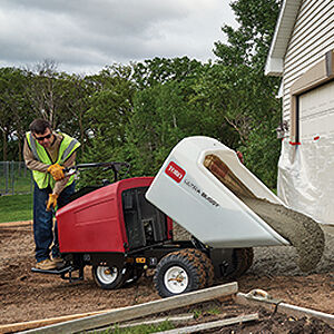 Wheeled Ultra Buggy white male dumping concrete for a new driveway.