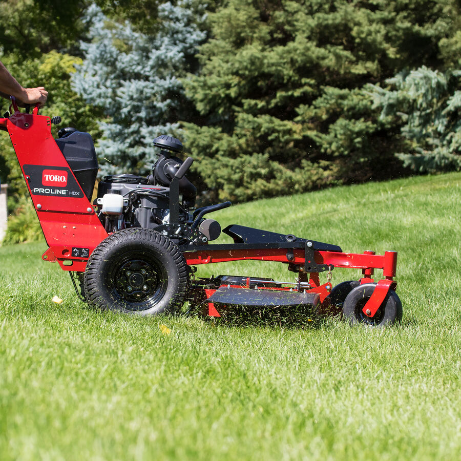 Close up of the Toro Proline Midsize mower mowing grass with the clippings being discharged from the side discharge chute.