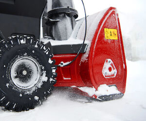 Close up of the side of a Toro snow blower's tires and intake area