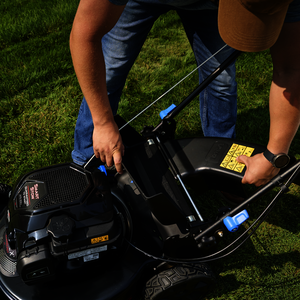 Man mowing with a Toro mower, model 21485. Mower has a grass catcher bag attached.