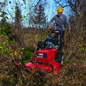 Brush cutter cutting through thick brush