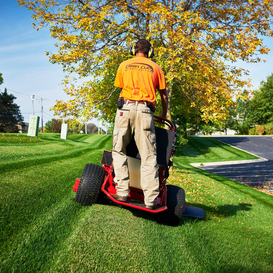 Man using a Toro GrandStand mower - image shown from the back of the mower. 