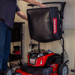 Space Saver - mower with handle up against a wall with bagger on handle