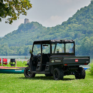 4 passenger workman utx parked in the grass by the water