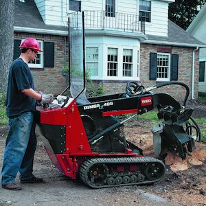 Dingo 425 with the stump grinder attachment in front of house